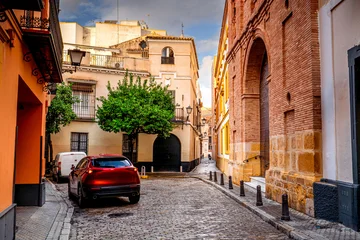 Fototapete Rund Enge Straßen Colorful narrow streets in a Spanish city with traditional architecture and parked cars, Seville, Andalusia.  © Tomasz