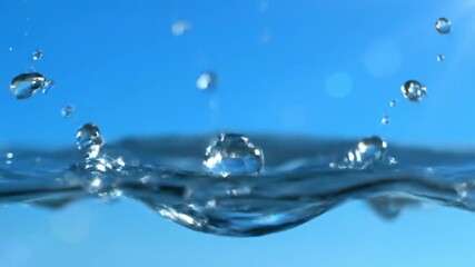 Mesmerizing slow motion capture of water droplet impacting the surface creating a crown-shaped splash against bright blue background - Powered by Adobe
