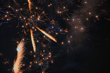 Spektakularny nocny pokaz fajerwerków na ciemnym niebie z wielobarwnymi smugami. © Pol Badger