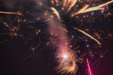 Spektakularny nocny pokaz fajerwerków na ciemnym niebie z wielobarwnymi smugami. © Pol Badger