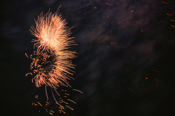 Spektakularny nocny pokaz fajerwerków na ciemnym niebie z wielobarwnymi smugami. © Pol Badger