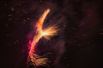 Spektakularny nocny pokaz fajerwerków na ciemnym niebie z wielobarwnymi smugami. © Pol Badger