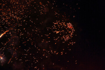 Spektakularny nocny pokaz fajerwerków na ciemnym niebie z wielobarwnymi smugami. © Pol Badger