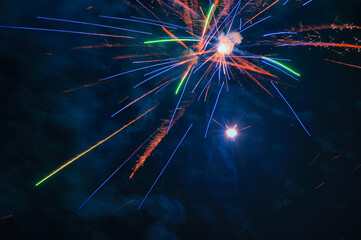 Spektakularny nocny pokaz fajerwerków na ciemnym niebie z wielobarwnymi smugami. © Pol Badger