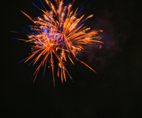 Spektakularny nocny pokaz fajerwerków na ciemnym niebie z wielobarwnymi smugami. © Pol Badger