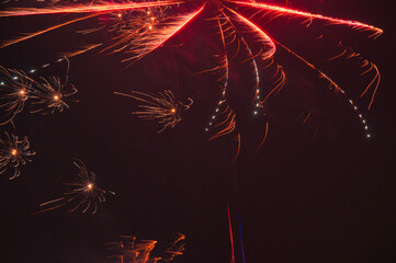 Spektakularny nocny pokaz fajerwerków na ciemnym niebie z wielobarwnymi smugami. © Pol Badger