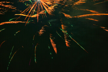 Spektakularny nocny pokaz fajerwerków na ciemnym niebie z wielobarwnymi smugami. © Pol Badger