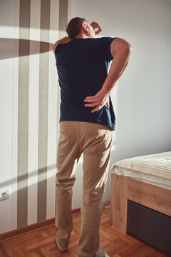 Man with hip, back, spine and sciatica pain at home.