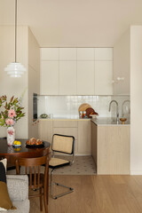 Obraz premium Cozy modern apartment interior with dining area, kitchen, and neutral tones