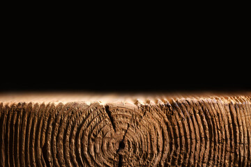 Old wooden board with a voluminous texture and cracks on black background. Can be used like stand for your object