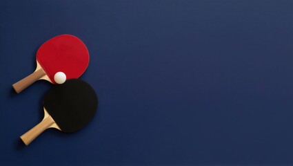 Two table tennis paddles, one red and one black, with a white ball resting on a blue background. Sports equipment for table tennis.