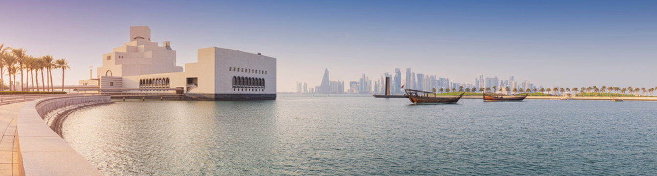 29 November 2025, Doha, Qatar: Museum of Islamic Art architecture against the modern cityscape, traditional dhow boats floating on calm Persian Gulf