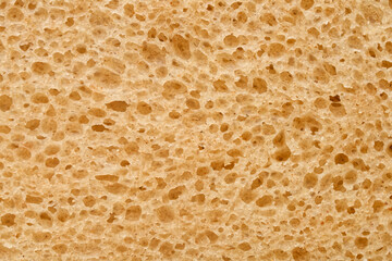Close-up of cut sourdough loaf inside. Abstract beige yeast sponge texture with holes. Healthy rustic nutrition concept and bakery shop backdrop. Photo