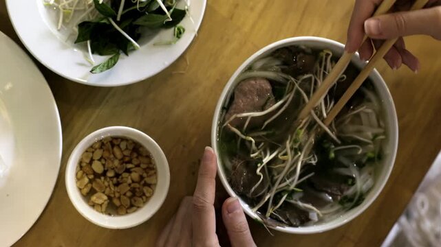 Preparing delicious vietnamese pho with fresh ingredients and traditional toppings