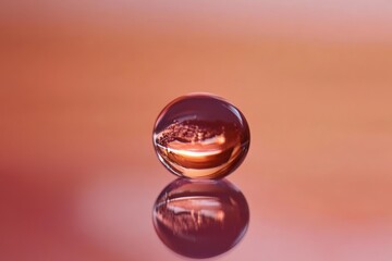 Minimalist close-up of a transparent sphere on a reflective surface