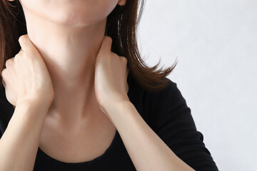 首元を押さえる女性　肩凝り