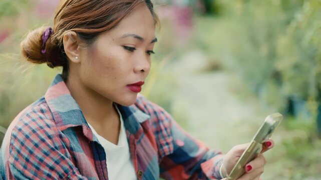 Young Woman Using Smart phone in Garden