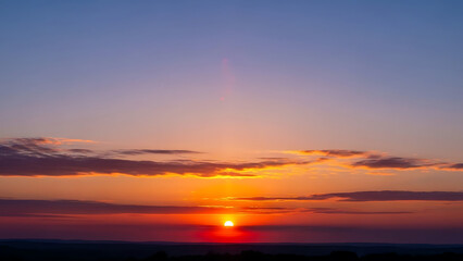Vibrant sunset over vast horizon with colorful sky and glowing sun