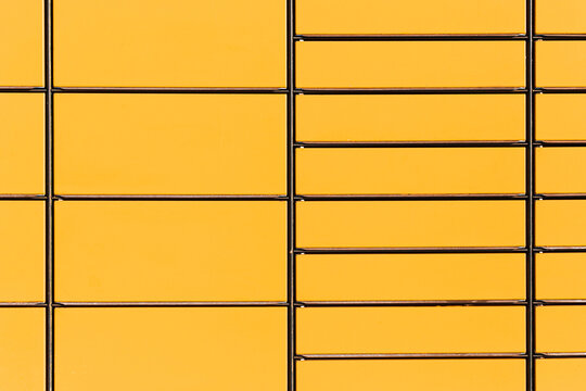 Yellow parcel locker wall. Automated parcel machine compartments. Modern self service delivery lockers. Urban logistics infrastructure background. Package pickup system for ecommerce shipping service