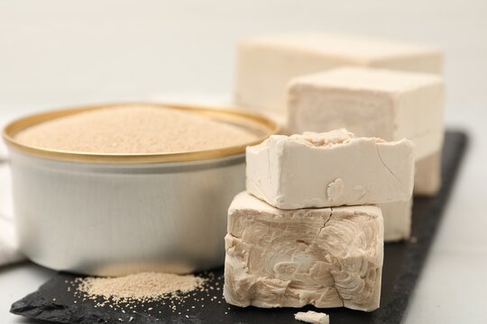 Dried yeast in bowl and fresh ones on light table, closeup