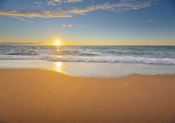 Summer on the beach. Sandy seashore during sunset.