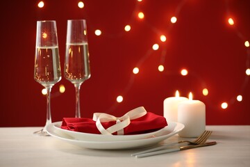 Beautiful place setting with burning candles on light wooden table