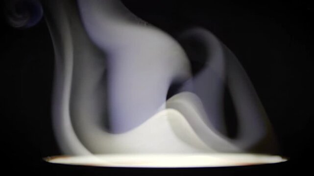 Cinematic white steam rising from hot drink silhouette on black background