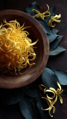 Elegant Ylang-Ylang petals in a wooden bowl with lush leaves, perfect for fragrance, wellness, and botanical-themed commercial projects