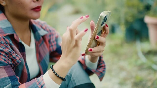 Young Woman Using Smart phone in Garden