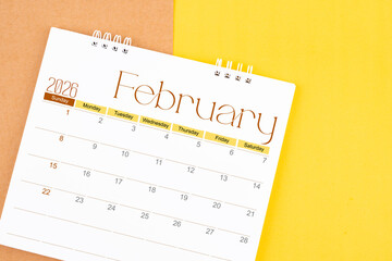 February 2026 desk calendar on brown and yellow, Planning for business.
