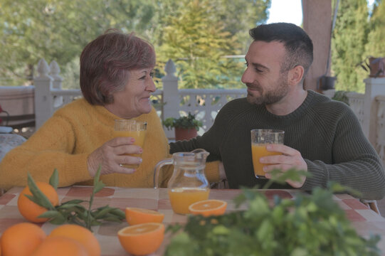 Madre e hijo desayunando zumo de naranja reci&eacute;n exprimido en una casa de campo