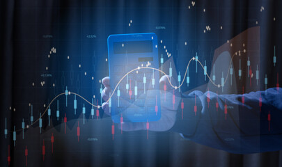 A human hand holds a blue calculator against the background of glowing stock market charts