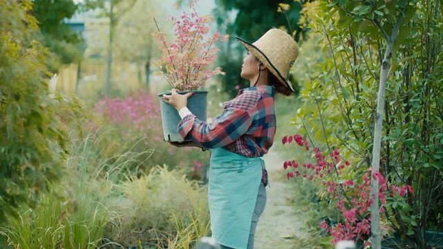 Woman with potted plant in a vibrant garden