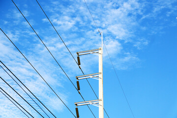 Power Lines Against a Bright Blue Sky with Fluffy Clouds Above