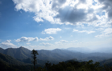 Expansive Mountain View Under Blue Skies with Fluffy White Clouds