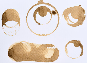 A set of assorted coffee stains and ring marks on a white paper background