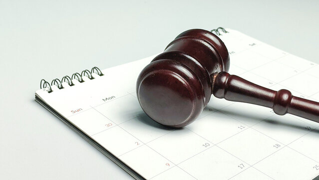 Court date and legal deadline concept featuring wooden judge gavel on calendar notebook