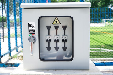 Breaker box.Electrical distribution box on public park with grass field background.