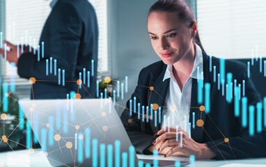 Confident businesswoman working on laptop with digital financial graphs overlay in office background, symbolizing creative business strategy concept