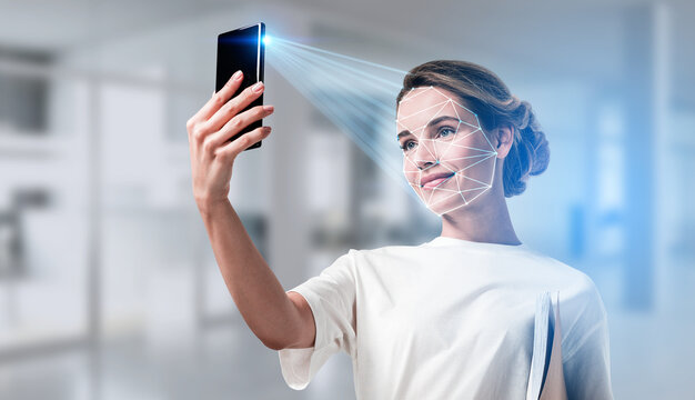 Woman holding smartphone for facial recognition scan, geometric face grid overlay, modern office background, concept of secure business technology - Powered by Adobe