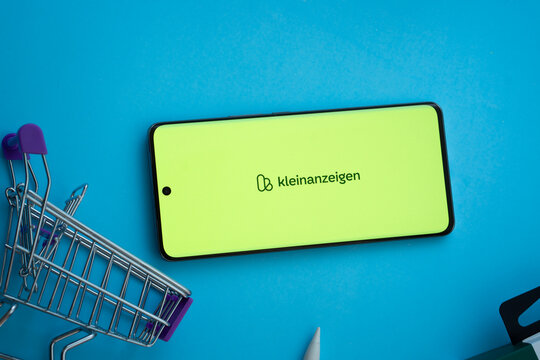 Dhaka, Bangladesh- 03 July 2025: Smartphone displaying Kleinanzeigen logo with shopping cart on a blue background.