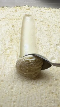 A tablespoon scoops up white pastry cream