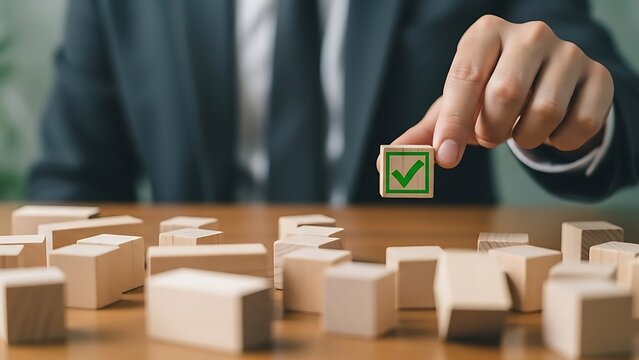 Business professional holding a wooden block with a green checkmark over scattered puzzle pieces symbolizing selection and ultimate successful task completion strategy.