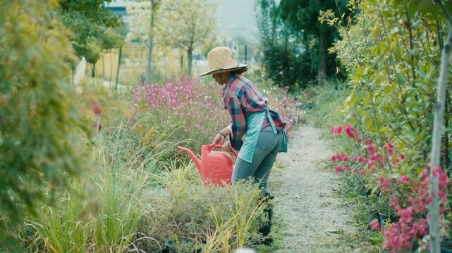 Woman watering plants in a vibrant garden