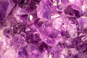 Amethyst purple crystals. Gems. Mineral crystals in the natural environment. Texture of precious and semiprecious stones. Seamless background with copy space colored shiny surface of precious stones.