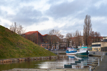 Fototapeta premium Scenic City Canal with Docked Boats and Modern Architecture