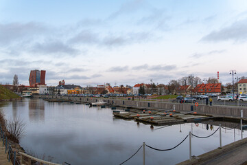Obraz premium Urban Marina Waterfront with City Buildings and Parked Cars