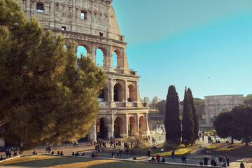 Iconic Colosseum landmark in Rome, Italy, surrounded by ancient ruins and green spaces as visitors...