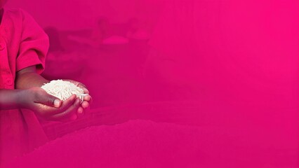 This image highlights the significance of staple foods in global nutrition. A child’s hands cradle uncooked rice, symbolizing sustenance, cultural heritage, and food security. 