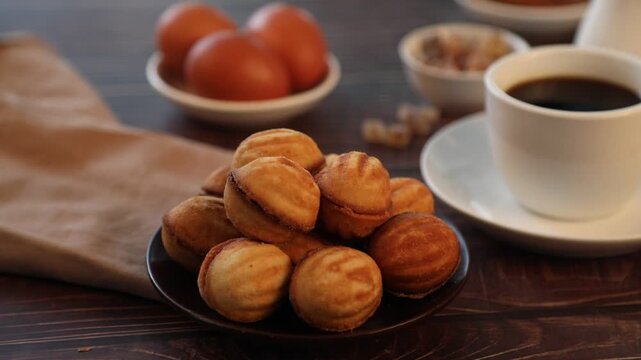 Walnut shaped cookies with condensed milk filling. Sweet homemade oreshki pastry on wooden background.